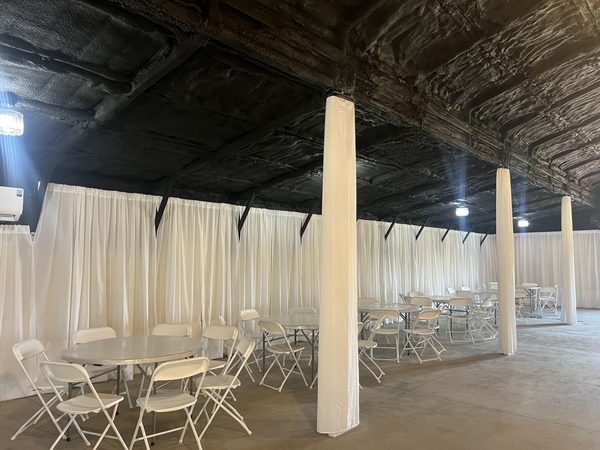 Draped interior set with tables and chairs